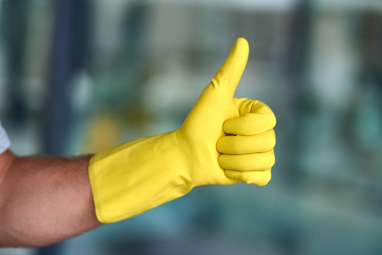 Thumbs-up from a professional janitor equipped with yellow cleaning gloves