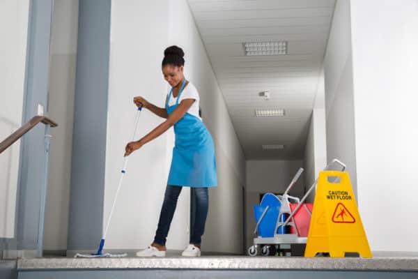 professional janitor safely & efficiently cleaning an office hallway in Hampton, VA